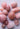 Collection of polished pink rose quartz stones arranged on a soft light surface