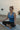 Woman meditating at sunrise by the sea, blue tones, throat chakra awareness